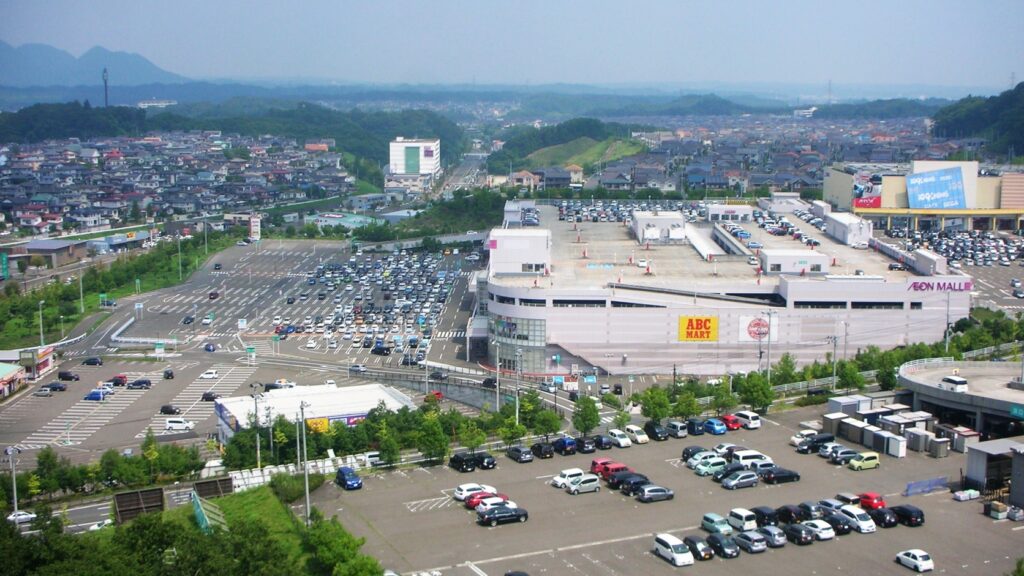 イオンモール富谷を高台から見た風景。広い駐車場と店舗、奥に住宅地が広がる