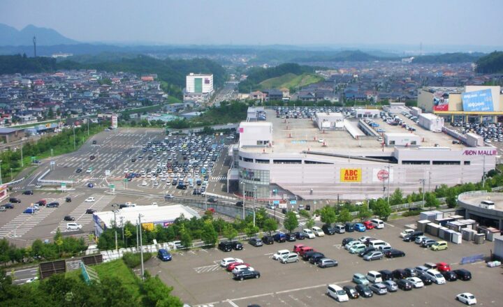 イオンモール富谷を高台から見た風景。広い駐車場と店舗、奥に住宅地が広がる