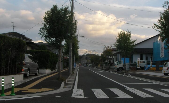 あけの平一〜二丁目の街並み。街路樹の並ぶ道と住宅、商店が続く