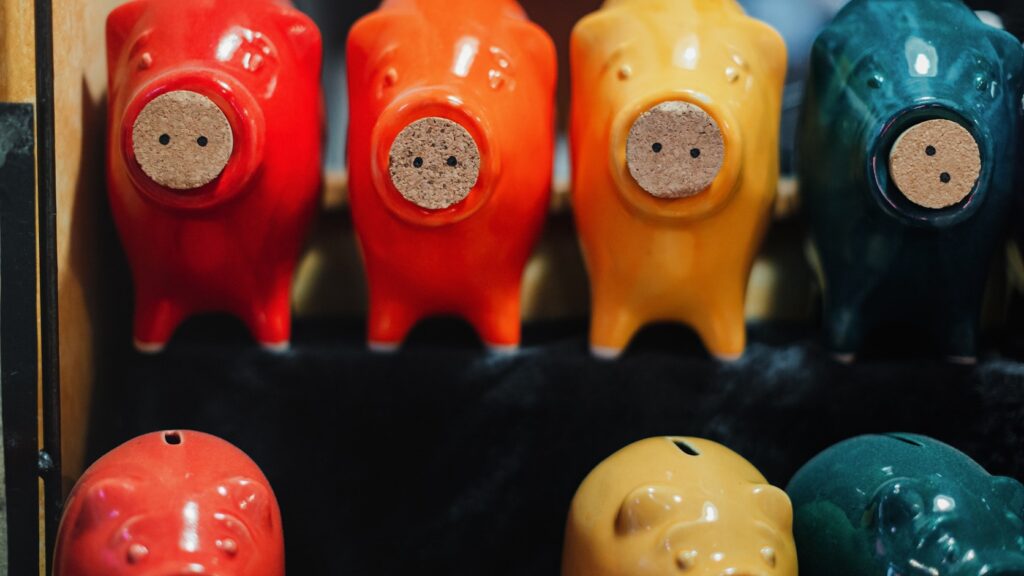 色とりどりの子ども向け貯金箱が並ぶ関連イメージ写真