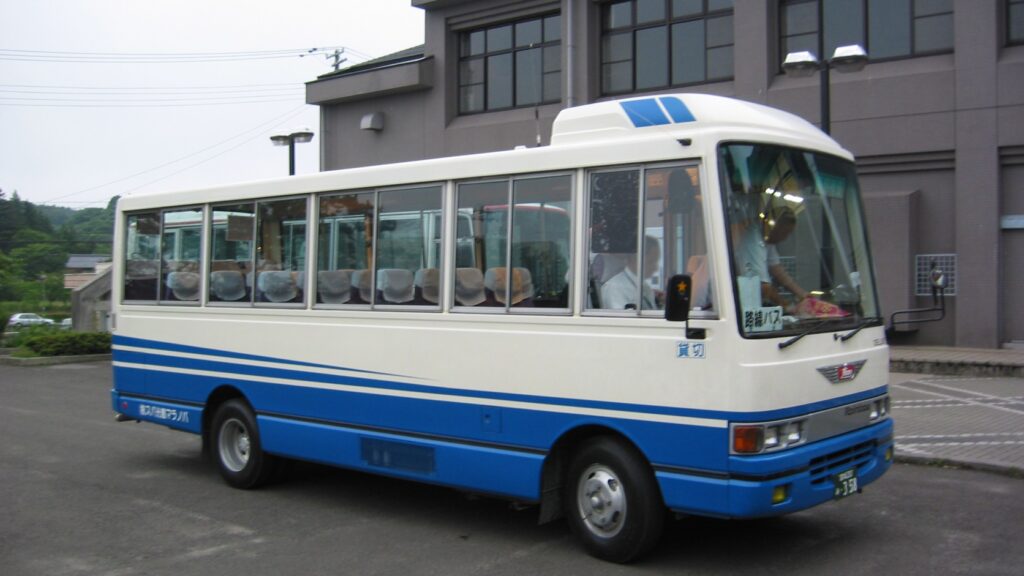 富谷市の市民バス。青と白の車体が建物の前に停まっている