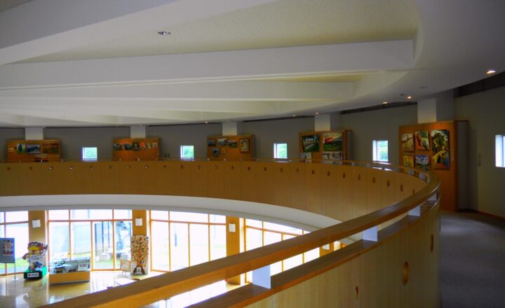 富谷市民交流ホールの回廊。曲面の手すりに沿って展示のモニターが並ぶ