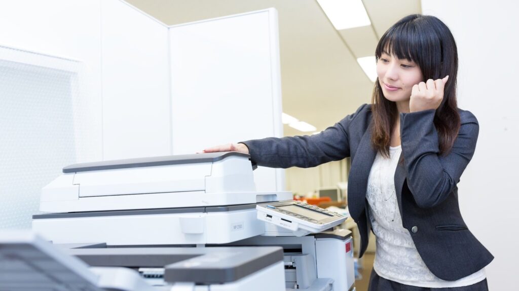 大型の複合機を操作する女性