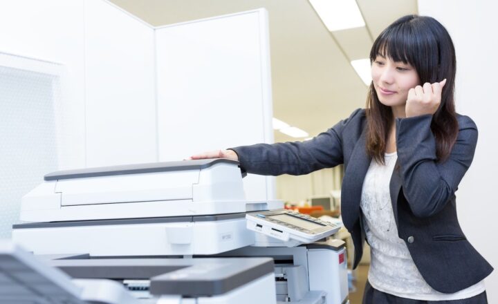 大型の複合機を操作する女性