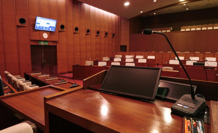 津山市議会の議場にある演壇マイク、議席、電子表決システムのモニター