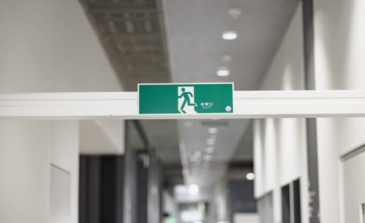 公共施設の廊下に掲げられた緑色の非常口サイン
