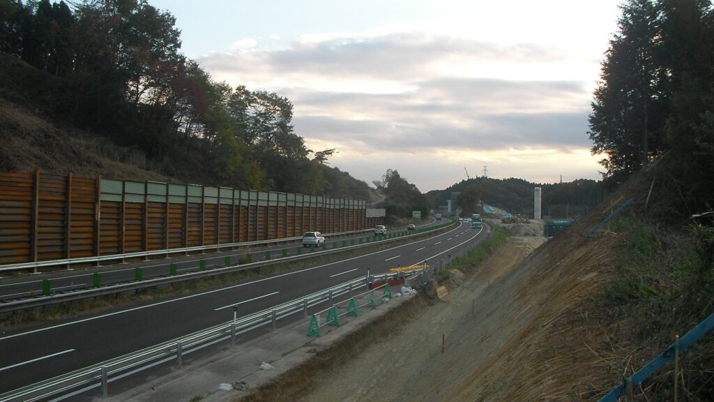 富谷ジャンクション付近の自動車道。防音壁の脇を車道がカーブして続く