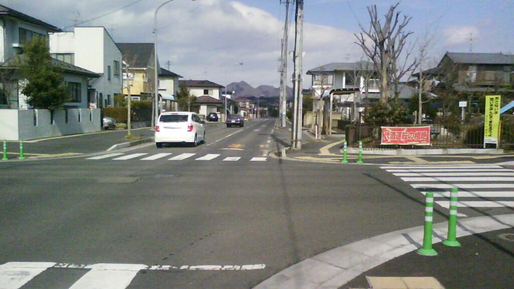 富谷町時代の住宅街の交差点。横断歩道と信号機、奥に住宅が並ぶ