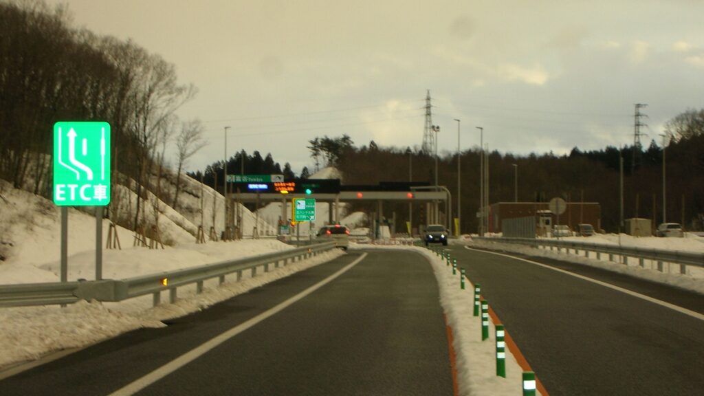 富谷インターチェンジの料金所へ向かう道路。ETC専用レーンの案内標識が立つ